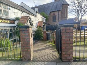 From street facing venue. Pillars on left and right. Path at centre.