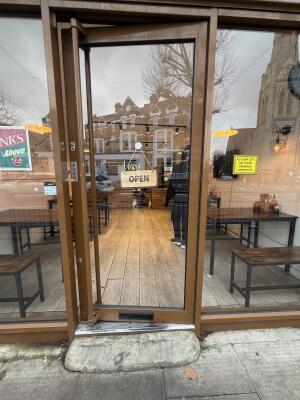 Glass door with brown metal frames ahead. Push from left to open.