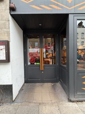 Glass doors with grey wooden frames ahead. Pull from center to open.
