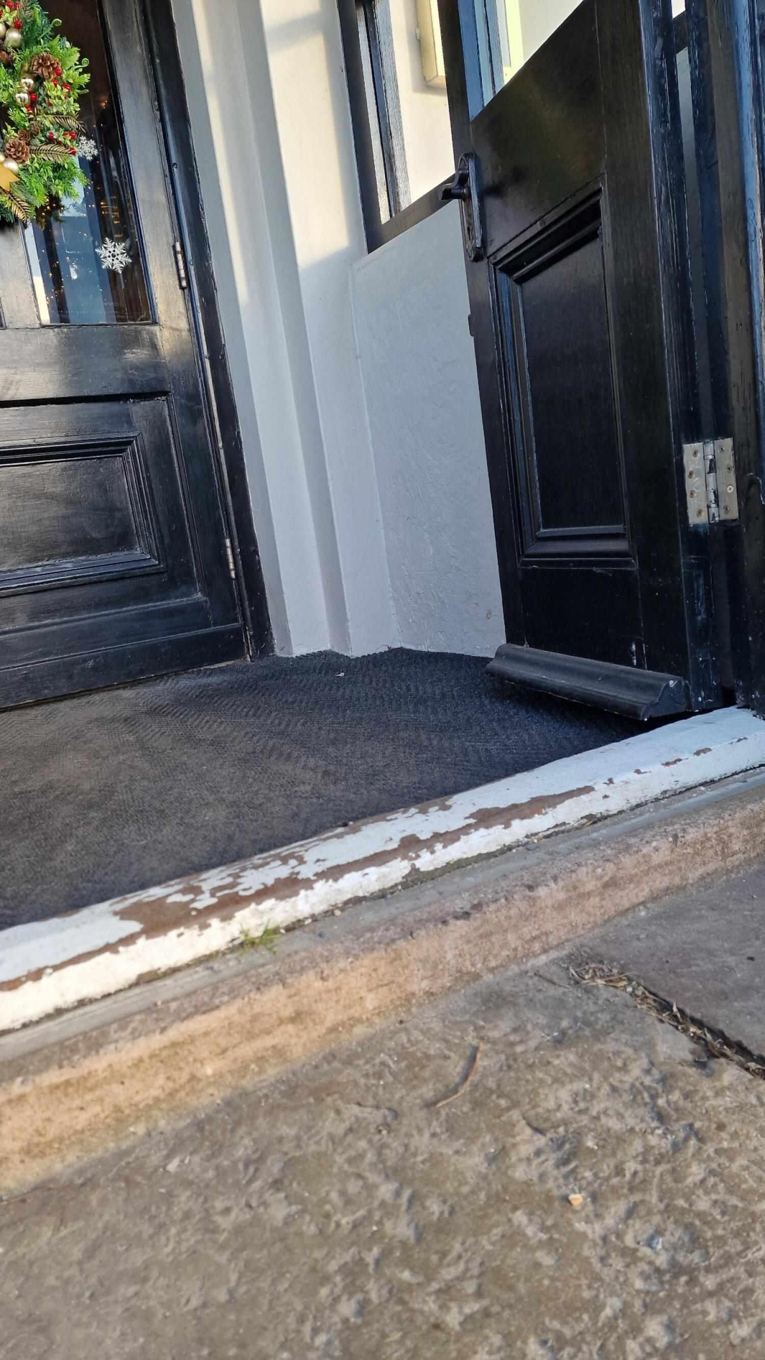 One step up before door. Doormat immediately after threshold.