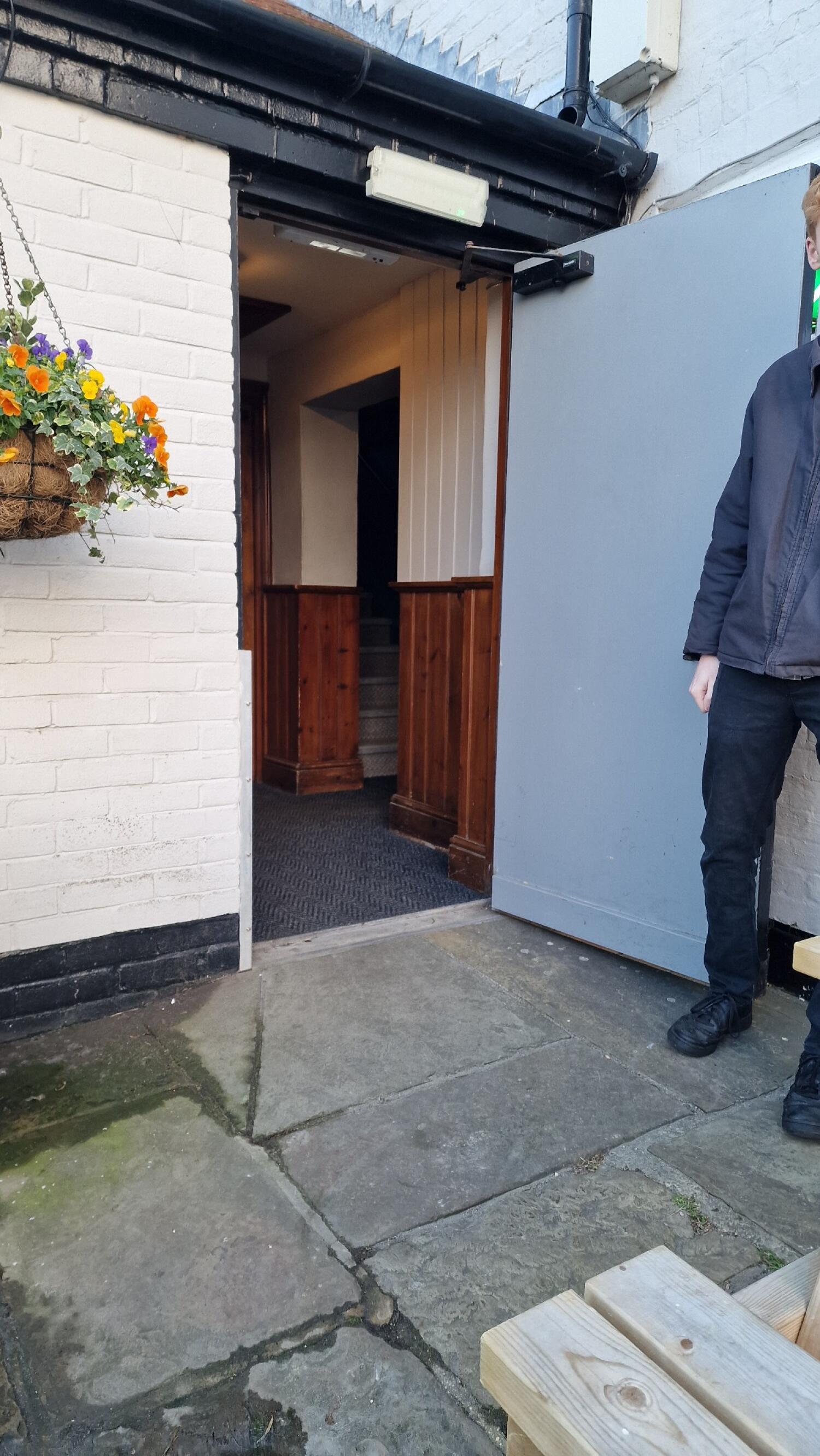 Grey metal door. Push from edge on left to open.