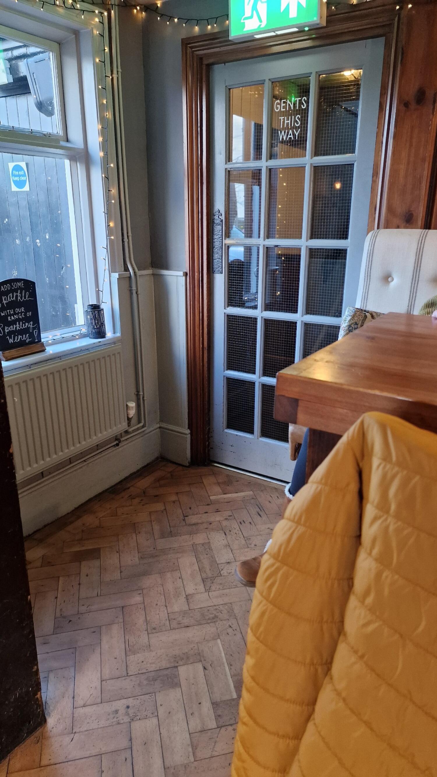 Light blue wood-framed glass door. Pull from handle on left to open.