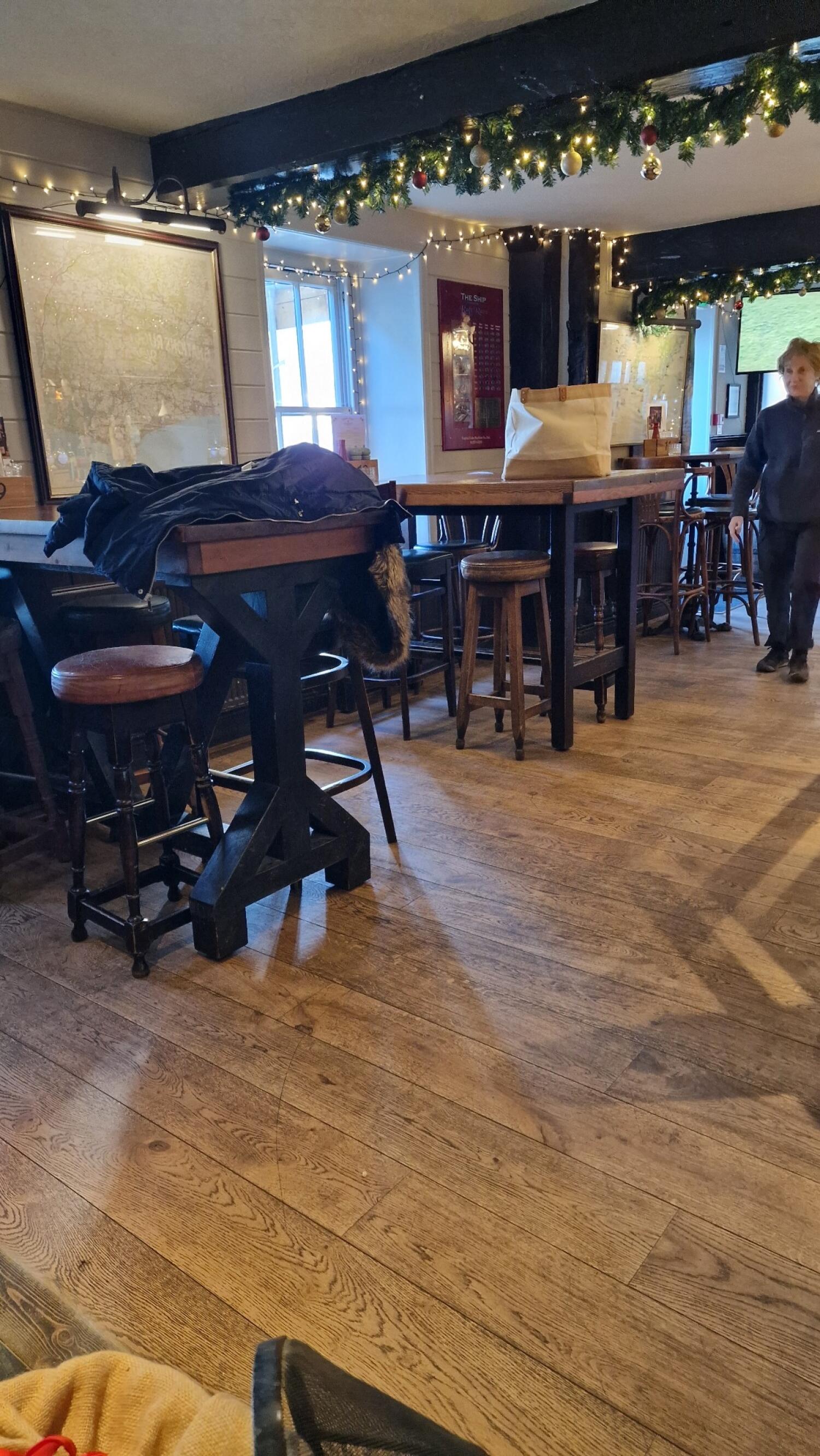 High tables with stools along left. More high tables in centre. Bar counter visible at back right.