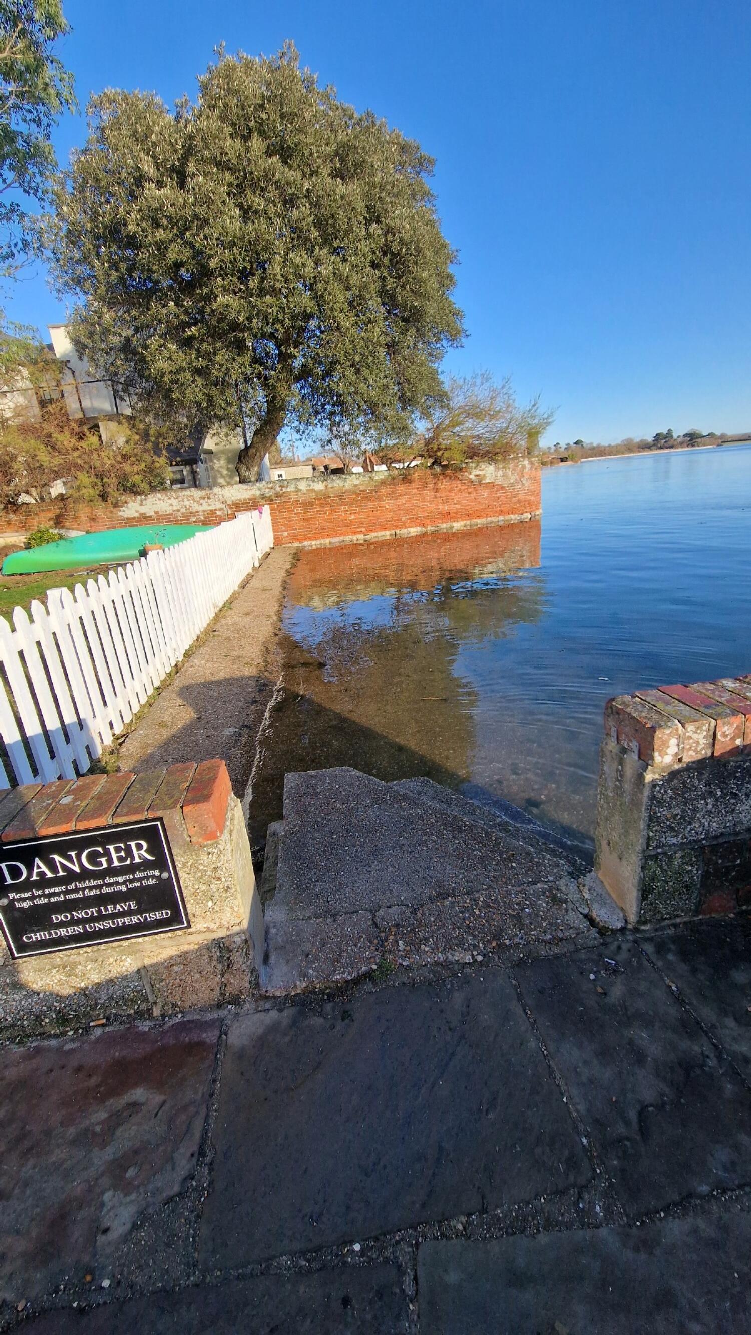 Staircase ahead, leading down into water. Handrail along left.