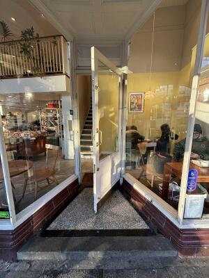 White framed glass door ahead. Pull handle on left to open.