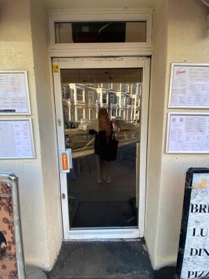 White framed glass door ahead. Pull silver handle on left to open.