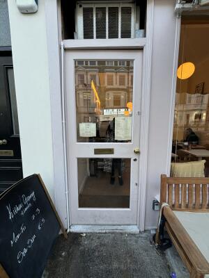 Pink framed glass door ahead. Push handle on right to open.