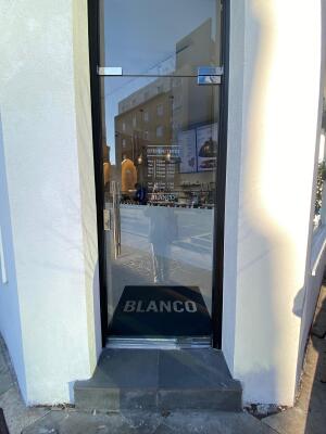 Black framed glass door ahead. Pull handle on left to open.