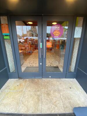 Grey frame glass double doors in front. Silver handle in center. Pull to open.