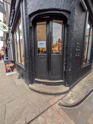 Grey wooden doors with glass panels in front. Push to open.