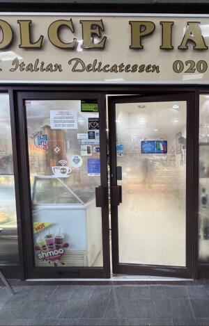 Glass doors with brown metal frames ahead. Push from center to open.