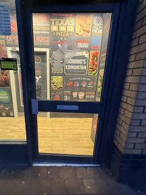 Glass door with blue metal frames ahead. Push from left to open.