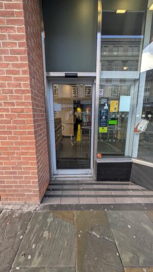 Silver metal-framed glass door. Automatic door slides to right to open.