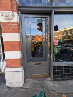 Grey frame glass door in front. Gold metal pad on right. Push to open.