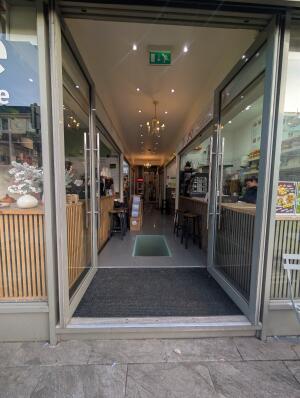 Grey framed glass doors ahead. Push handles in centre to open.