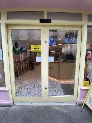 Yellow framed glass sliding doors. Doors automatically open from centre.