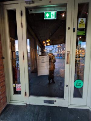 White frame glass door in front. Gold handle on right. Pull to open.