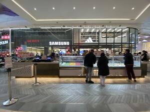 From pathway facing straight. Counter ahead. Till counter on left side. Display counter to its right.