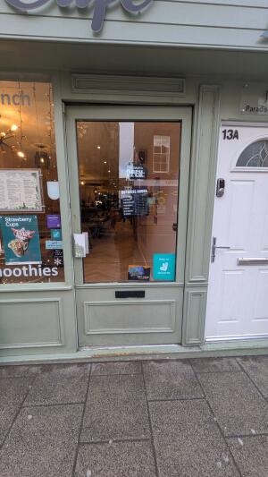 Light green wood-framed glass door. Push from handle on left to open.