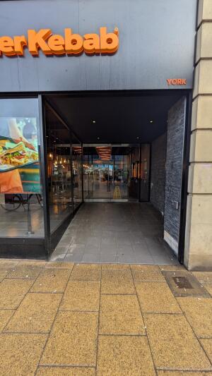 Open archway ahead. Glass doors after. Push handles in center to open.