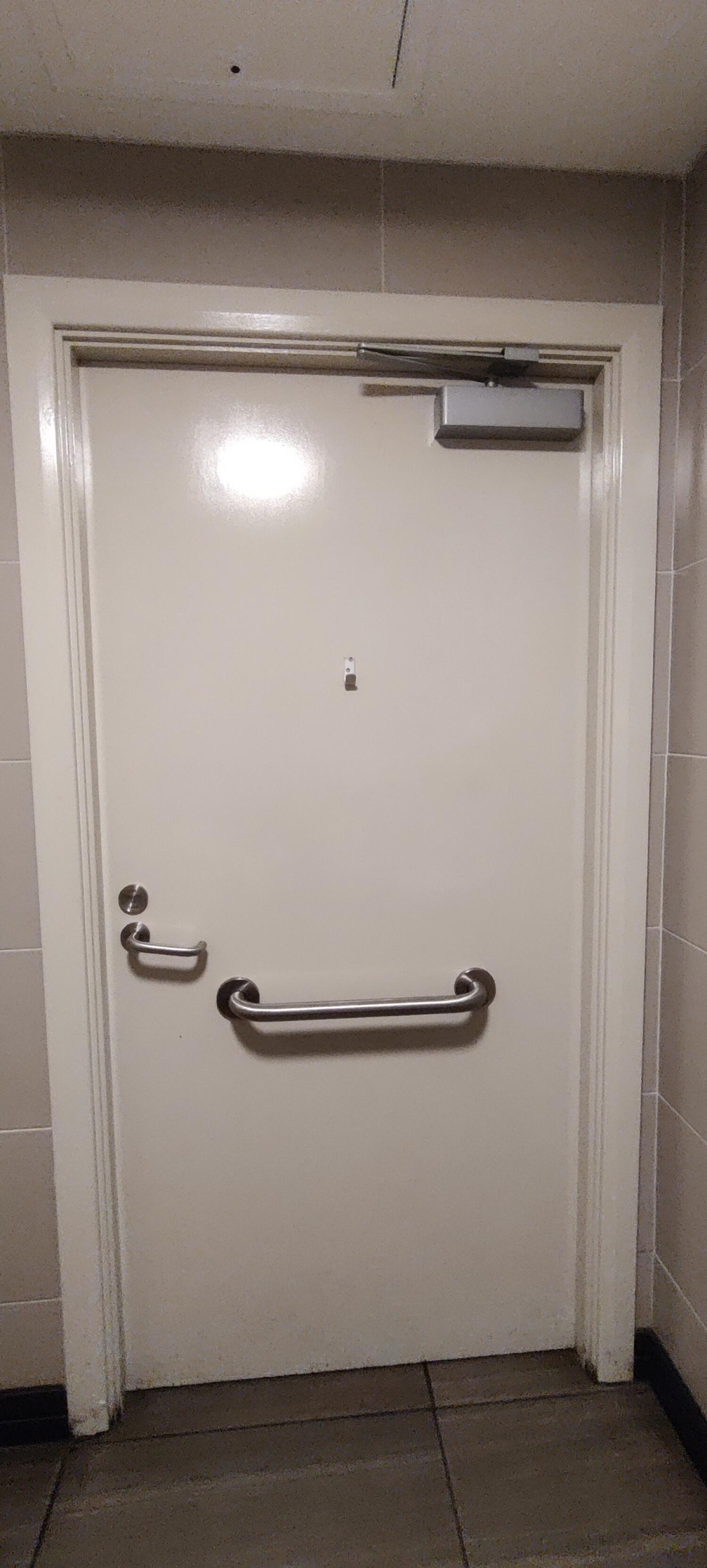 Back of door. Grab rail in the center. Twist metal handle on left.