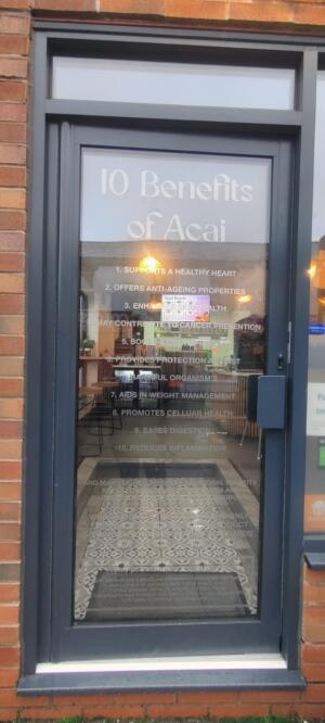 Grey metal-framed glass door ahead. Push metal handle on right.
