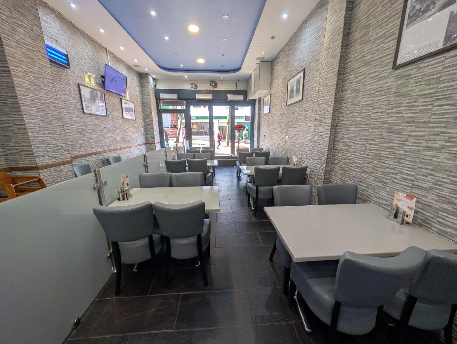 From opening facing left. Tables and chairs along both sides.