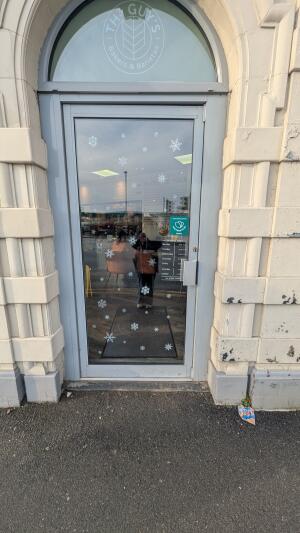 Grey metal-framed glass door. Push from handle on right to open.