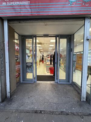 Grey metal framed archway ahead. Door at back.