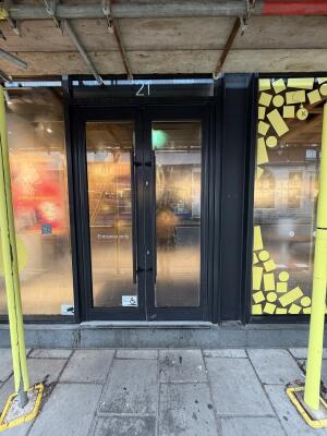 Glass doors with black frames ahead. Pull from center to open.