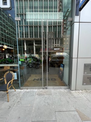 Double glass door with long handle in centre, push to open.