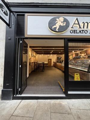 Glass door with black metal frames ahead. Fold from right to open.