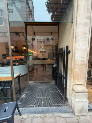 Black gate ahead. Push to open. Single glass door behind. Pull golden knob on right to open.