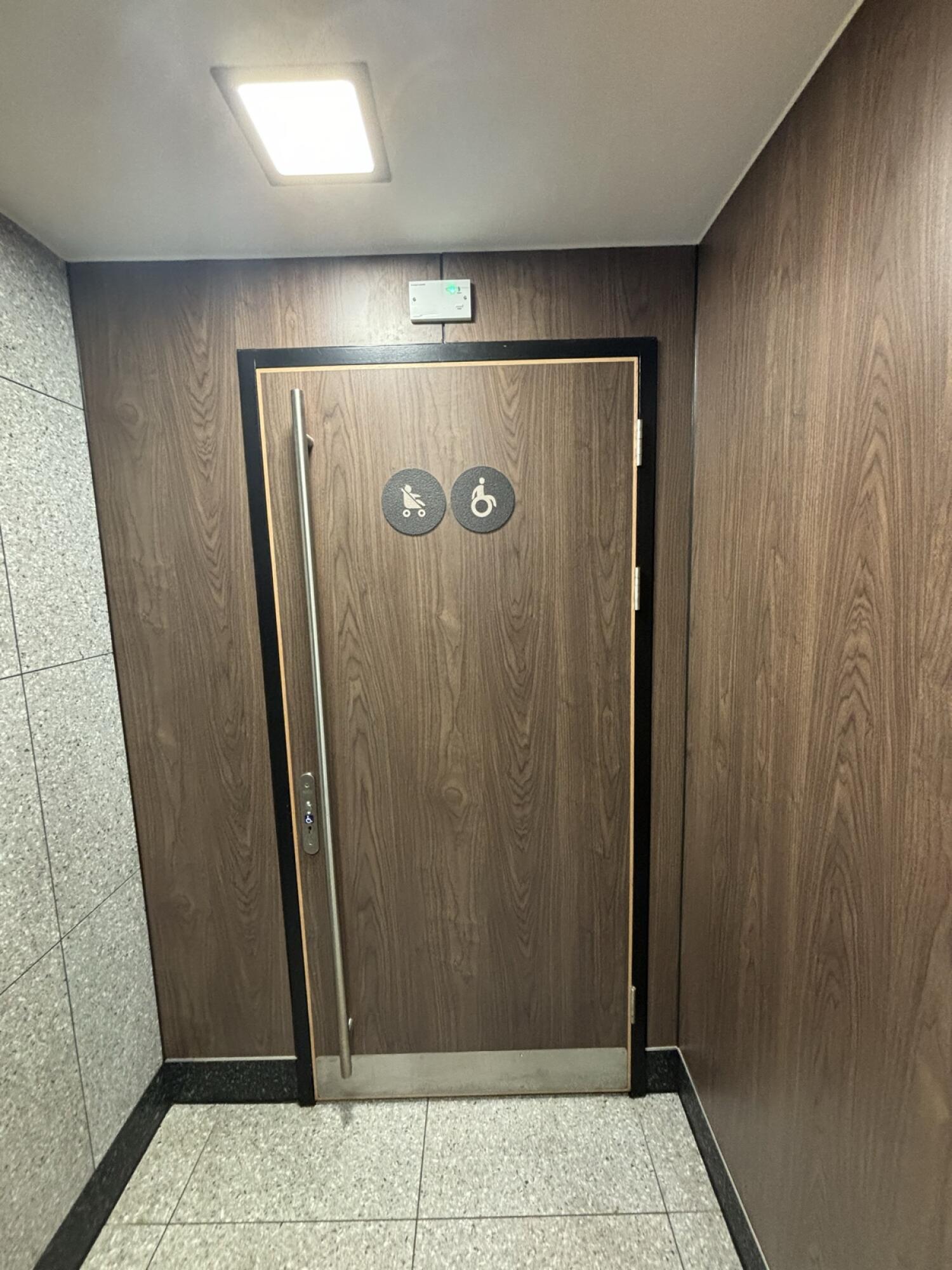 From en dog path facing right. Black framed drown toilet door ahead. Pull handle on left to open. Radar key hole on left.