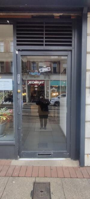 Grey metal framed glass door ahead. Twist and push knob at left to open.