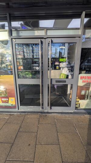 Grey metal-framed glass doors. Push from metal handles at centre to open.