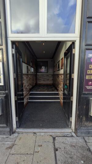 Black wood-panelled glass doors. Push in center to open.