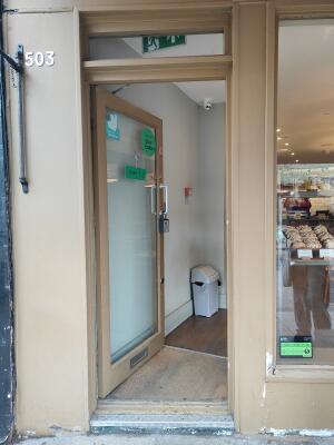 Brown framed glass door ahead. Push silver handle on right to open.