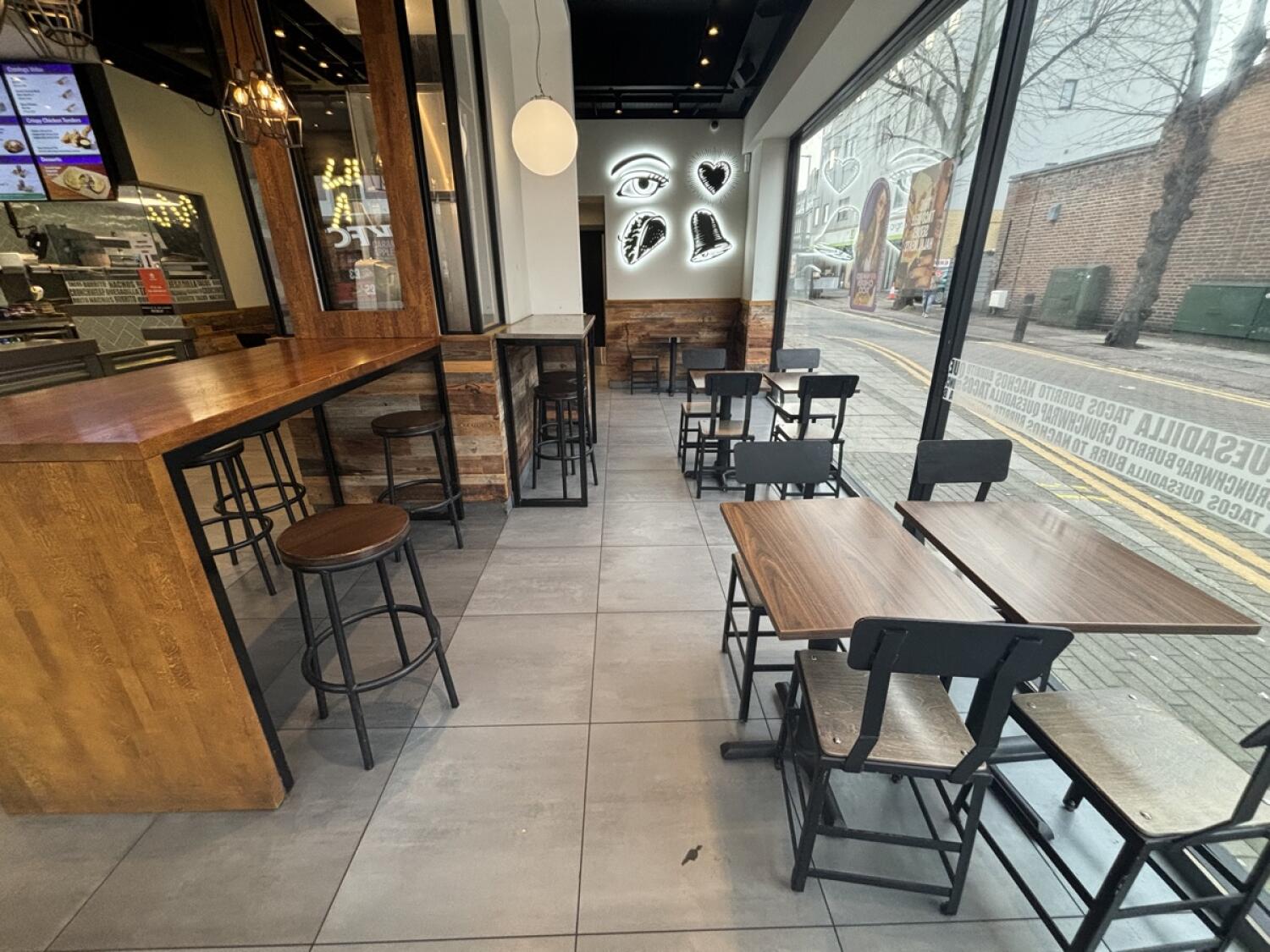 From second opening facing left. Tables and chairs on right. High table and stools on left.