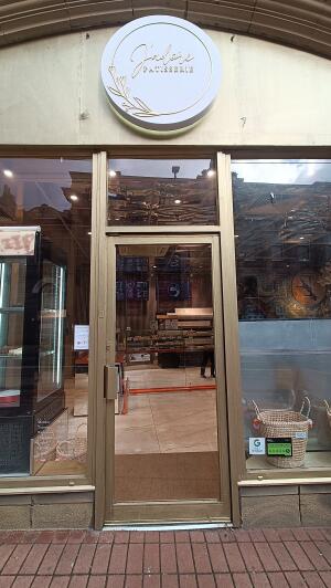 Gold framed glass door to venue. Push handle on left to open.