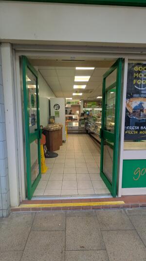 Green metal-framed glass doors. Push from handles at centre to open.