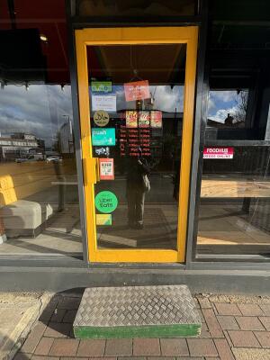 Yellow framed glass door ahead. Push handle on left to open.
