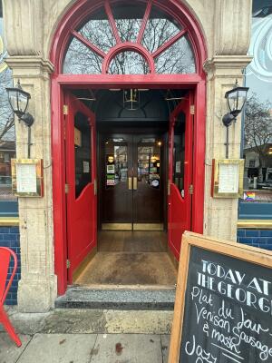 Red framed glass panel doors ahead. Push from centre to open.