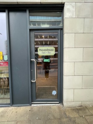 Glass door with grey frame. Push silver handle on left to open.