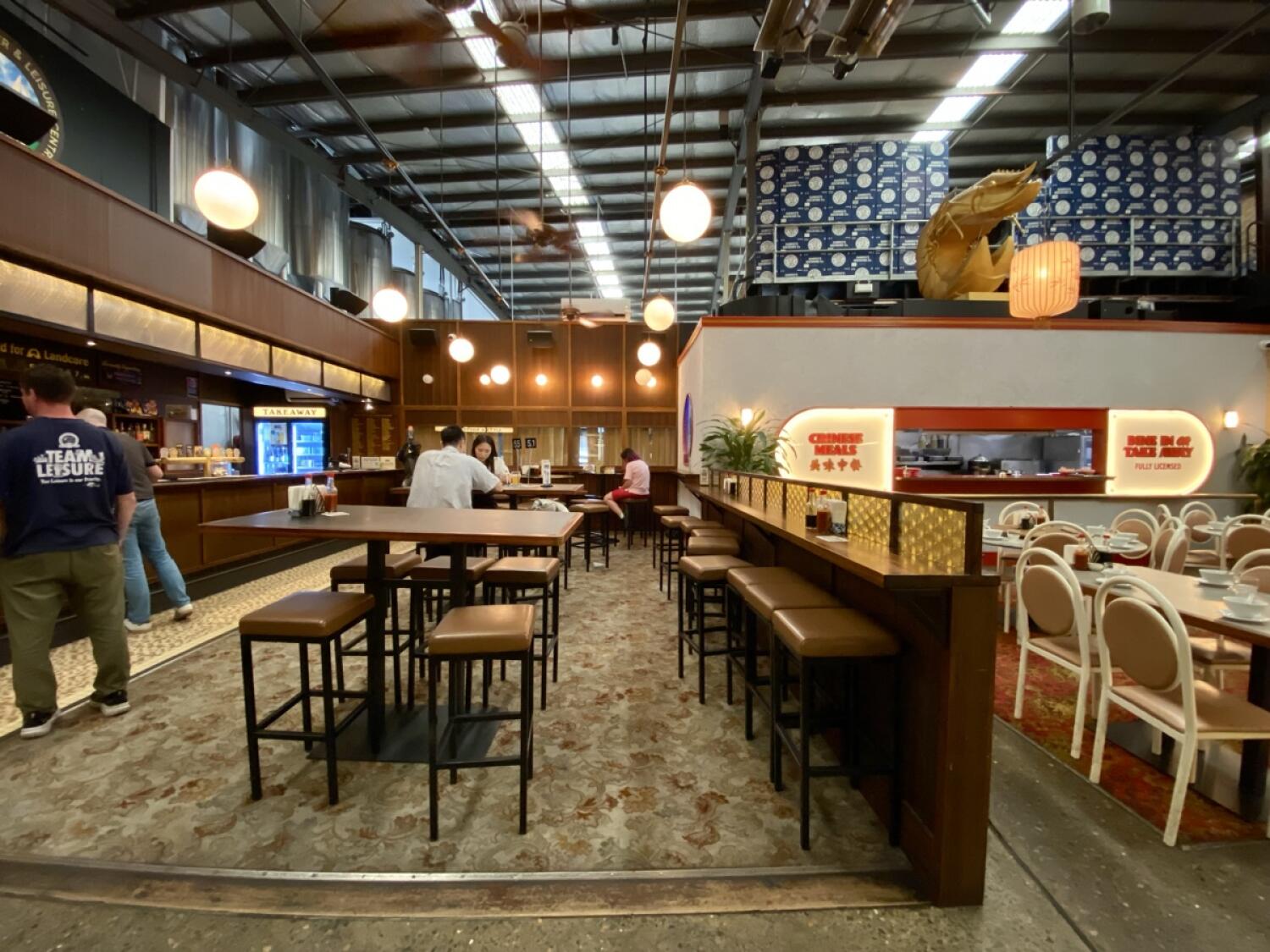 From opening facing right. High tables and stools ahead. Path on left to bar and food counter.