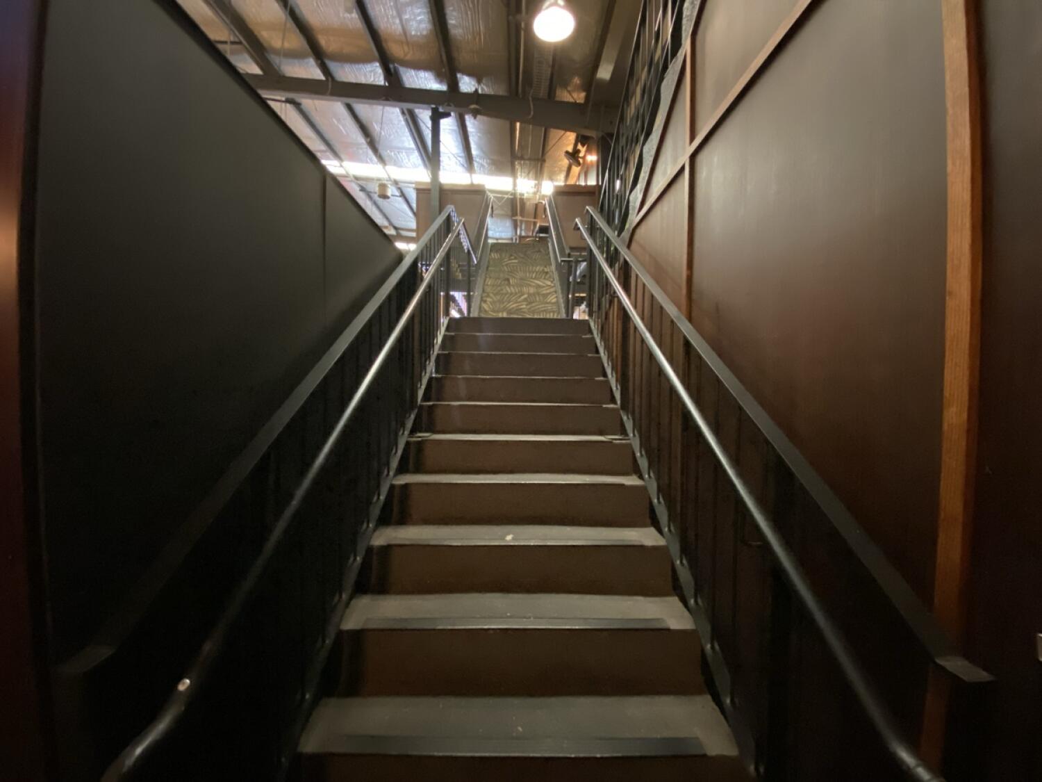 From opening facing left. Staircase ahead, leading up. Handrails along left and right.