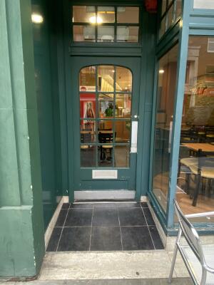 Green wood-framed glass door. Push from right to open.