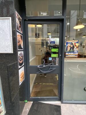 Black metal-framed glass door. Push from right to open.