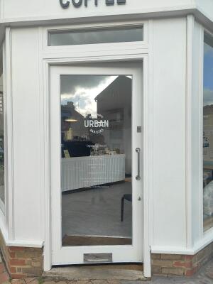 White-framed glass door. Pull from metal handle on right to open.