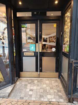 Black wood-framed glass doors. Push from centre to open.